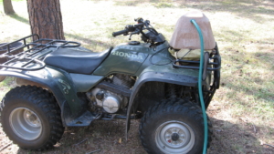 Watering rock on 4 wheeler being filled with hose