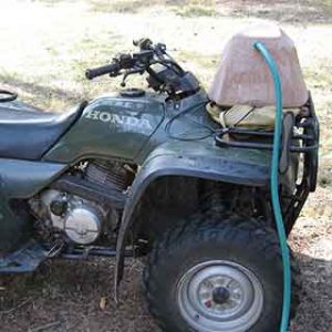 Watering rock on 4 wheeler being filled with hose