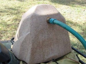 Watering rock being filled with hose