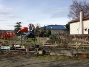 Picture of a Farm with a Large Black Boot and Red Hat